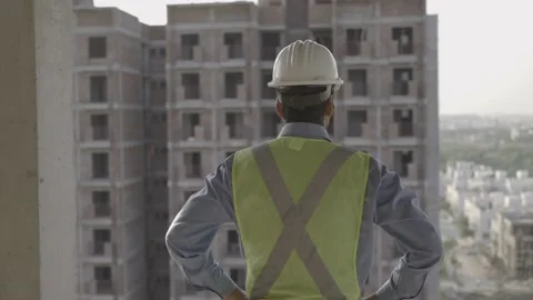 A back shot of a male engineer standing against under construction site Stock Footage 146441013