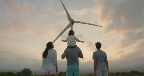 Back Shot of a Man Carrying his Child on His Shoulders and Walkingin a Wind farm Stock Footage 250362276