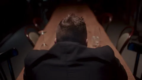 Back shot of a man sitting alone at the table and drinking Vídeo Stock 258332699