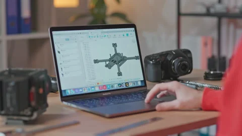 Back shot of skilled young man sitting at workplace and working on drone Stock Footage 186160572