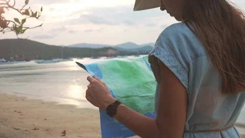Back Shot Slow Motion of Young Woman. Holding Paper Guide Map in Hands on Beach Stock Footage 109132382