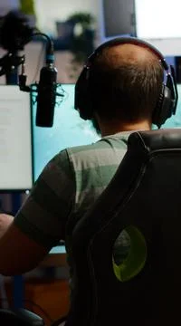 Back shot of streamer man playing on powerful computer shooter video game Fotos Stock