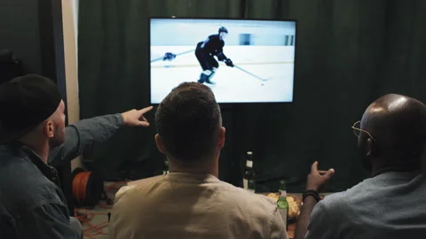 Back Shot Of Three Multiracial Friends Watching Hockey Game On TV At Home Stock Footage 238842344