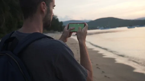 Back Shot of Young Man 4K Searching in Smartphone Map on Beach. Stock Footage 109088088