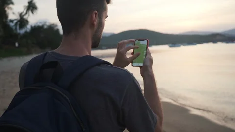 Back Shot of Young Man 4K Searching in Smartphone Map on Beach. Stock Footage 109088170