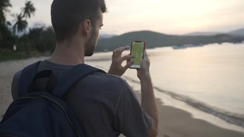Back Shot of Young Man 4K Searching in Smartphone Map on Beach. Stock Footage 109088517
