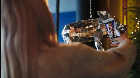 Back shoulder view of long-haired blonde woman taking selfie indoors. Modern Stock Footage 104565252