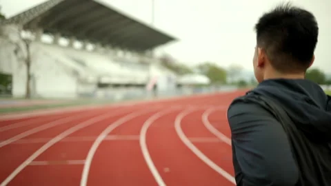Back side attractive young man wearing sportswear running on track at sport. Stock Footage 172522707