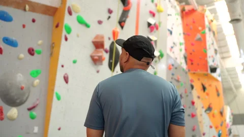 Back side of Confident man enjoys indoor climbing as part of his urban fitness l Stock Footage 316150608