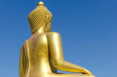Back side of golden buddha with deep blue sky background Foto stock