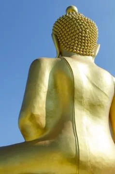 Back side of golden buddha with deep blue sky background Stock Photos