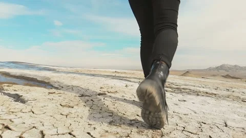 Back side of shoes stepping on white volcanic terrain in slow motion. Backgro Stock Footage 146741472