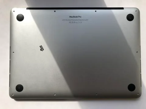 Back side of silver MacBook Pro 13 with the screws off. Laptop repair concept Fotos Stock