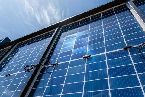 Back side of solar panels in solar energy plant in front of blue sky. Product Stock Photos