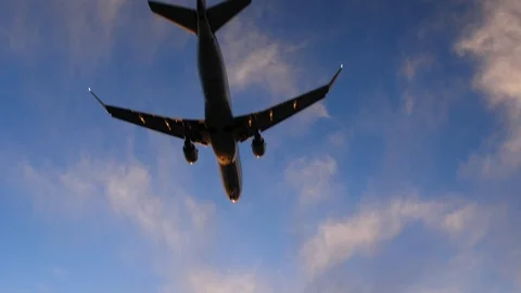 Back side view of a big commercial aircraft flying straight over head Stock Footage 104849083