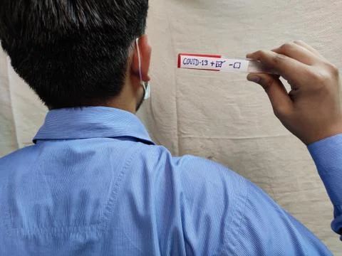 Back side view of Man holding Corona positive test sample Stock Photos