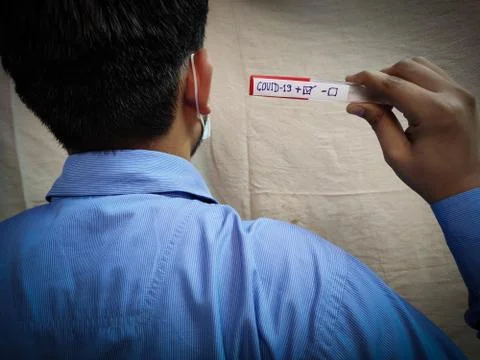 Back side view of Man holding Corona positive test sample Stock Photos