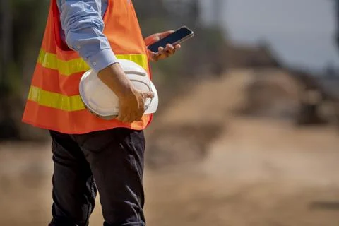 Back side view of a Man holding White helmet close up. Construction workers w Stock Photos