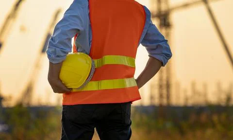 Back side view of Man holding White helmet close up. Construction workers wor Stock Photos