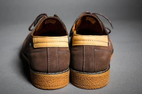 Back side view of men's suede shoes with thick soles and leather inserts on grey Stock Photos