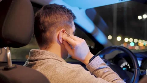 Back sit shot of an exhausted man in mask, using bluetooth headphones and Stock Footage 143499879