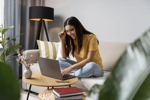Back to study. Happy student doing her work at home on laptop in a cosy room Stock Photos
