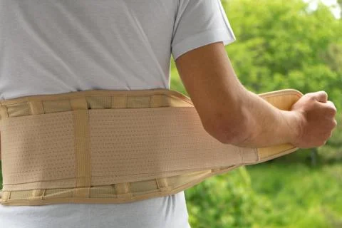 Back support for muscle back. Man wearing orthopedic brace to support core an Stock Photos