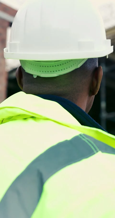 Back, thinking and man with helmet at building site, safety compliance and Stock Footage 336791844