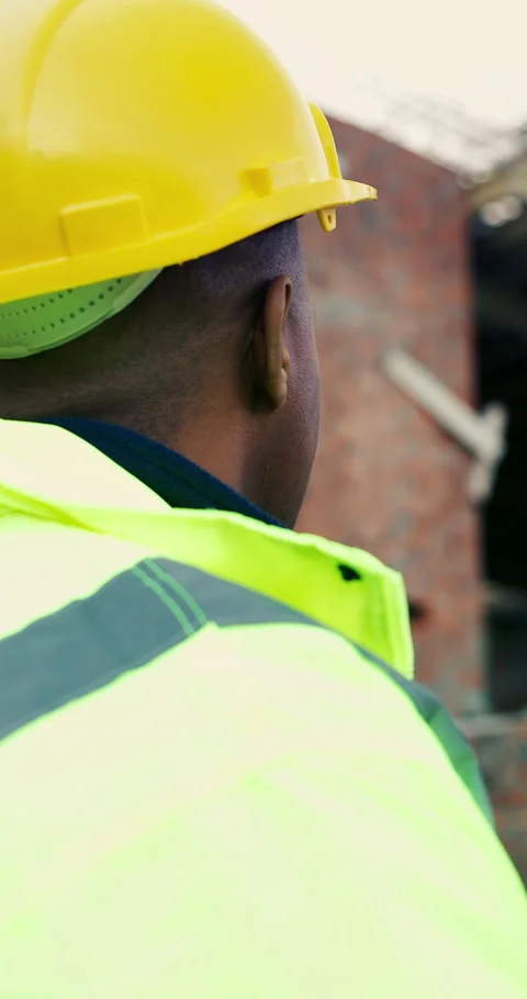 Back, thinking and man with helmet at construction site, safety compliance and Stock Footage 336800993