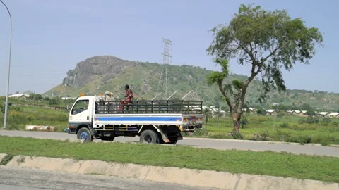 In the back of a truck rides dark skinned man Stock Footage 100607690