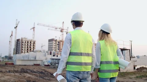 Back turned engineer and controller at construction site reviewing office Stock Footage 114276436
