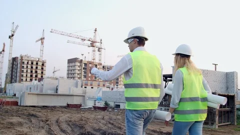Back turned engineer and technician at construction site reviewing office Stock Footage 114272328