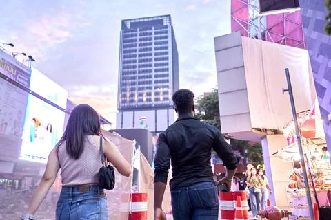 Back of two people walking through a modern shopping centre Stock Photos