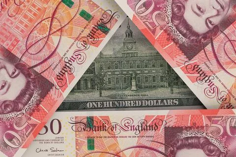 Back of a US $100 bill peeks out from under British pound notes. Foreign Ex.. Foto stock