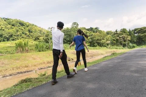 Back view of active asian couple walking exercise at rural area Fotos de archivo