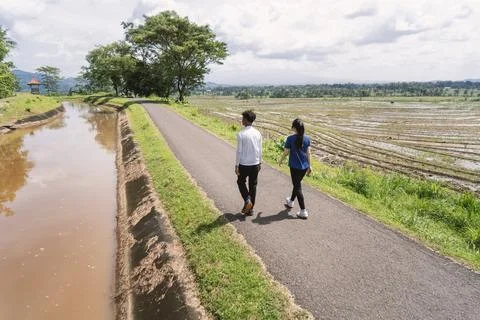 Back view of active asian couple walking exercise at rural area Fotos de archivo