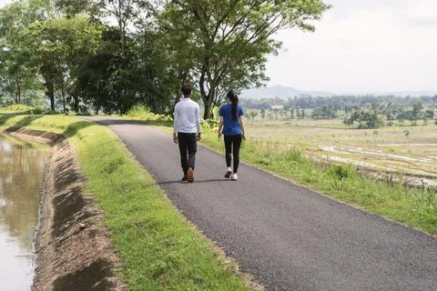 Back view of active asian couple walking exercise at rural area Stock Photos