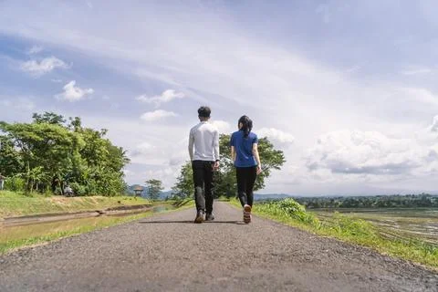 Back view of active asian couple walking exercise at rural area Fotos de archivo