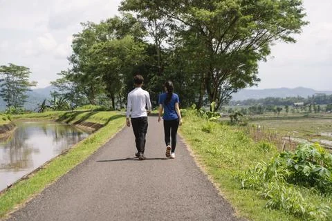 Back view of active asian couple walking exercise at rural area Stock Photos