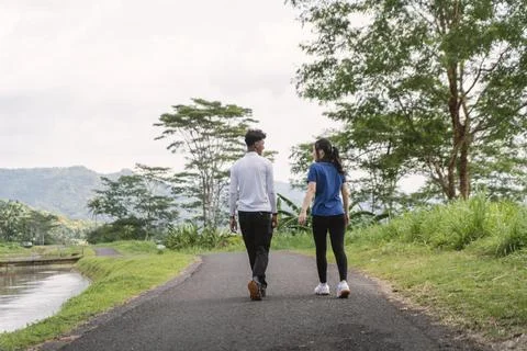 Back view of active asian couple walking exercise at rural area Stock Photos