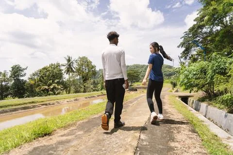 Back view of active asian couple walking exercise at rural area Stock Photos