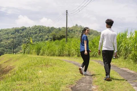 Back view of active asian couple walking exercise at rural area Stock Photos