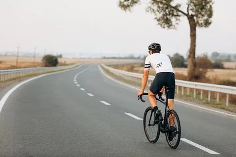Back view of active man riding bike on fresh air Stock Photos