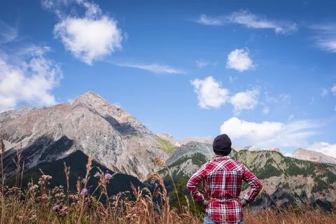 Back view of active woman looking and enjoying mountain and sky view in summe Stock Photos
