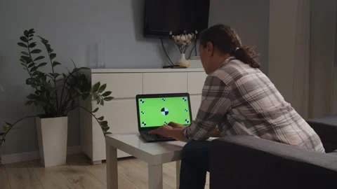 Back view of adult female using, typing laptop with chroma key indoors Stock Footage 167929131