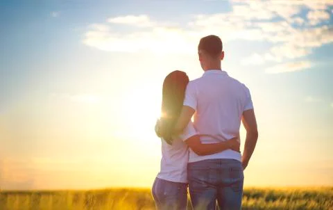 Back view of affectionate young couple stand closely, admire nature, see some Stock Photos