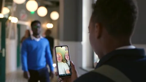 Back view of African-American boy have video chat with classmates on smartphone Stock Footage 243640199