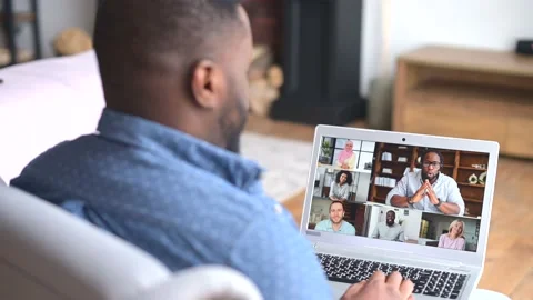 Back view an African-American young man is using laptop for video meeting with Stock Footage 158923692