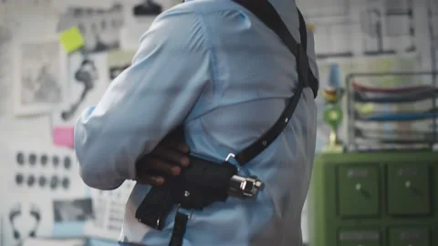 Back view of african sheriff looking at board with evidence standing at police Видео 142794754