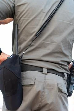 Back view of alerted undercover cop or security agent reaching hand gun attached Foto stock